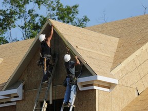 Carpenters work on installing trim at a housing site.
REUTERS file pic
