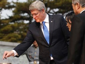 Prime Minister Stephen Harper burns incense during his visit to the National Cemetery in Seoul March 11, 2014. REUTERS/Kim Hong-Ji