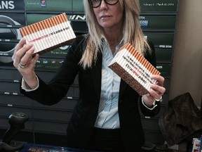 Jacqueline Bradley, the executive director of the National Coalition Against Contraband Tobacco, holds up contraband cigarettes Tuesday, March 11, 2014. (DAVE THOMAS/Toronto Sun)