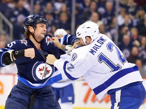 Winnipeg Jets defenceman Mark Stuart (5) and Tampa Bay Lightning forward Ryan Malone (12) fight at centre ice during the first period at MTS Centre earlier this year. (REUTERS)