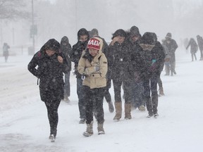 Queen's University students bundled up to face the blowing snow whipping down University Avenue during the late winter storm on Wednesday March 12, 2014. Julia McKay/Kingston Whig-Standard/QMI Agency