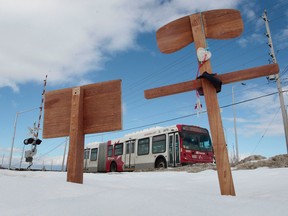 A OC Transpo bus crosses the tracks near Fallowfield Road in Ottawa On. Tuesday March 11,  2014.  A buss passes two crosses at the scene of a deadly crash between an OC Transpo bus and a Via Rail train last year. Tony Caldwell/Ottawa Sun/QMI Agency