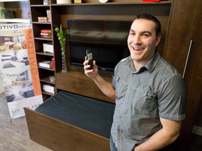 Anthony Dos Reis shows off an automated Murphy bed in the showroom at Motivo Interiors on Exeter Rd in London. (DEREK RUTTAN, The London Free Press)