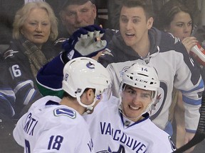 Canucks right winger Alexandre Burrows (right) celebrates his second period goal against the Jets with defenceman Ryan Stanton (BRIAN DONOGH/Winnipeg Sun)