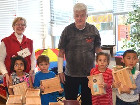 University Heights Public School kindergarten teacher Lynn Hill and some of her students stand around a handful of birdhouses created by James Symons, also pictured. The students have an outdoor class where they learn about nature and they were surprised to receive a birdhouse that they could take home and report their observations back to their classmates.