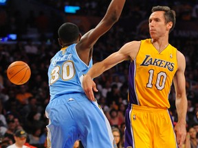 Los Angeles Lakers guard Steve Nash (10) passes the ball around Denver Nuggets forward Quincy Miller (30) during NBA action at Staples Center. (Christopher Hanewinckel/USA TODAY Sports)