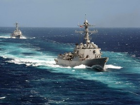 The Arleigh Burke-class guided-missile destroyers USS Kidd and USS Pinckney are seen en transit in the Pacific Ocean in this U.S. Navy picture taken May 18, 2011.  Kidd and Pinkney have been searching for the missing Malaysian airliner and are being re-deployed to the Strait of Malacca of Malaysia's west coast as new search areas are opened in the Indian Ocean, according to officials on March 13, 2014.   REUTERS/US Navy/Seaman Apprentice Carla Ocampo/Handout