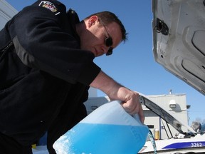 Const. Pete Dawson fills up the windshield washer fluid reservoir of his cruiser. Most traffic officers go through one jug every two days when the weather is like this — and they expect you too as well. Cops warn fines of $110 apply to drivers caught with dangerously dirty windshields or side windows. DOUG HEMPSTEAD/Ottawa Sun/QMI Agency