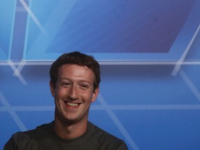 Facebook CEO Mark Zuckerberg smiles in the stage before delivering a keynote speech during the Mobile World Congress in Barcelona Feb. 24, 2014. REUTERS/Albert Gea