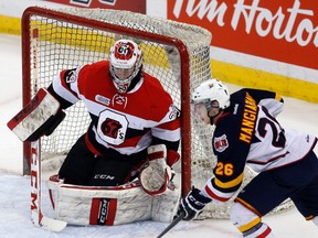 Barrie Colts' Andrew Mangiapane, right, looks to capitalize off a loose puck as Ottawa 67s' goalie Philippe Trudeau guards the net during the first period of OHL action at the Canadian Tire Centre in Ottawa, Ont. on Thursday March 13, 2014. Darren Brown/Ottawa Sun