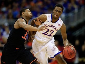 Kansas star Andrew Wiggins tries to drive by Oklahoma State's Marcus Smart in Big 12 tourney play on March 13. (Getty/AFP)