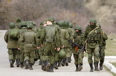Armed men, believed to be Russian servicemen, walk outside a Ukrainian military base in Perevalnoye, near the Crimean city of Simferopol, March 14, 2014. Russia shipped more troops and armour into Crimea on Friday and repeated its threat to invade other parts of Ukraine, showing no sign of listening to Western pleas to back off from the worst confrontation since the Cold War.  REUTERS/Vasily Fedosenko (UKRAINE - Tags: POLITICS MILITARY)