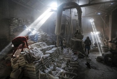 Employees work inside a limestone powder factory in an industrial area in Mumbai March 11, 2014. India's industrial output was seen falling 0.6 percent in January, according to the poll's consensus forecast, due to weak consumer demand and investment. The government will release the data on Wednesday. REUTERS/Danish Siddiqui