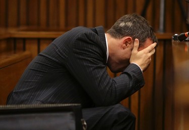Olympic and Paralympic track star Oscar Pistorius reacts as he reaches for a bucket in the dock during his trial for the murder of his girlfriend Reeva Steenkamp, at the North Gauteng High Court in Pretoria, March 10, 2014. Pistorius broke down on Monday when a South African court heard details from the autopsy of girlfriend Reeva Steenkamp, whom the track star is accused of murdering on Valentine's Day last year. REUTERS/Siphiwe Sibeko