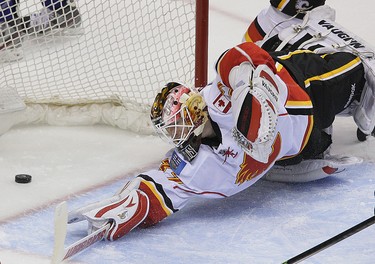 Calgary Flames’ goalie Joni Ortio looks back at the puck after getting scored on by Vancouver Canucks’ Yannick Weber during the third period of NHL game at Rogers Arena in Vancouver, B.C. on Saturday March 8, 2014. Carmine Marinelli/QMI Agency