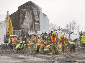 Emergency workers dig through the ruins of Residence du Havre in L?Isle Verte, Que. in January. A reader says lives may be lost between now and the end of 2015, when all retirement and group homes must be fitted with sprinklers. (QMI Agency file photo)