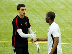 Ottawa Fury FC goalie Chad Bush slaps hands with Pierre-Rudolph Mayard at a recent practice. Bush will start in goal in an exhibition game tonight for the Fury . Darren Brown/Ottawa Sun