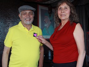 New Asian Village restaurant owner Harmeet Karpur, left, has a Purple Hearts Silver Lining pin placed on his shoulder by S.I.R.E.N.S volunteer Rosalie Moore-Anderson at the New Asian Village, 10143 Saskatchewan Drive, on Tuesday, March 11, 2014. Trevor Robb/Edmonton Sun/QMI Agency