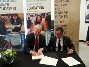 Stuart Murray CEO and president of the Canadian Museum for Human Rights and David Mandzuk, dean of education at the University of Manitoba, sign the agreement for the summer institute that signifies the first partnership between the two institutions, March 14, 2014. (KRISTIN ANNABLE/Winnipeg Sun)