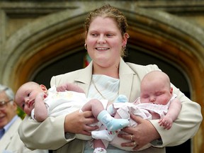 The world's first "test-tube baby" Britain's Louise Brown, faces the media holding 13-week-old twins Antonia and Henry Veary, as Prof. Robert Edwards looks on, during 25th anniversary celebrations of the revolutionary In Vitro Fertilisation (IVF) fertility treatment at Bourne Hall in Cambridgeshire in this 2003 file photo. 
Reuters/QMI Agency