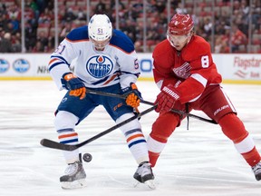 Detroit Red Wings left wing Justin Abdelkader (8) and Edmonton Oilers center Anton Lander (51) battle for the puck at Joe Louis Arena. Tim Fuller-USA TODAY Sports