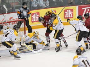 Sarnia Sting and Guelph Storm players battle while Sting goalie Brodie Barrick attempts to cover up the puck during their game on Friday, March 14 in Guelph. The Storm defeated Sarnia 13-1. (Photo courtesy METCALFE PHOTOGRAPHY)