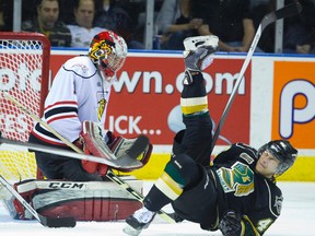 Knights forward Matt Rupert grimaces as he hits the ice after being dumped in front of Owen Sound Attack goalie Jack Flinn at Budweiser Gardens on Friday night. (MIKE HENSEN, The London Free Press)