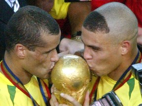Brazilian great Rivaldo (left) and Ronaldo kiss the World Cup trophy after their win in the 2002 tournament. (REUTERS/Oleg Popov/Files)
