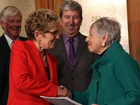 Premier Kathleen Wynne accepts the transit panel report from her appointed committee chair Anne Golden, as Transportation Minister Glen Murray looks on  at Queen’s Park on December 12, 2013. 
DAVE THOMAS/TORONTO SUN