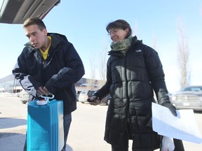 Alex Gilbert (left) of the city's recreation services helps Diana Borys load a water jug in her car at the Cindy Klassen Recreation Complex in Winnipeg, Man., on Sat., March 14, 2014. The city has set up the first of three frozen water pipe resource centres at the complex on Sargent Avenue. Kevin King/Winnipeg Sun/QMI Agency