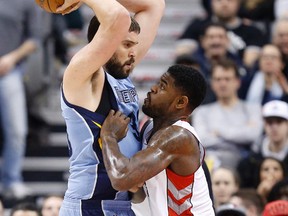 Raptors’ Amir Johnson plays tough defence against Grizzlies’ Marc Gasol on Friday. With 18 games left, the Raptors need to continue to play good team defence heading into post-season. (Craig Robertson/Toronto Sun)