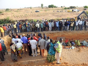A file picture taken on March 8, 2010 in Dogo Nahawa shows natives gathering at a mass burial of their kinsmen killed during a religious crisis.  At least 100 people were killed in weekend attacks on three villages in central Nigeria, local officials said on March 16, 2014. Scores of residents were also injured when about 40 assailants armed with guns and machetes stormed the villages of Angwan Gata, Chenshyi and Angwan Sankwai, attacking locals in their sleep and torching their homes, said Yakubu Bitiyong, a lawmaker at the Kaduna state parliament. (AFP PHOTO/ PIUS UTOMI EKPEI)