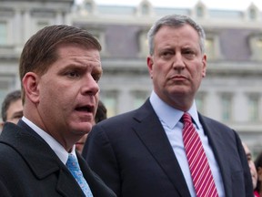 New York Mayor Bill de Blasio and Boston Mayor Martin Walsh (L) speak to the press outside the West Wing of the White House in Washington, December 13, 2013.  REUTERS/Jason Reed