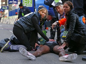 Mo Farah of Great Britain is taken care of by medical personal after he collapsed at the finish line after finishing in second place at the 2014 New York City Half Marathon in lower Manhattan on March. 16, 2014 in New York City. (Rich Schultz /Getty Images/AFP)