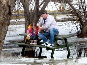 A father and daughter takes a break on a picnic bench surrounded by water at the John Janzen Nature Centre in Edmonton Alta., on Sunday March 16, 2014. Perry Mah/Edmonton Sun/QMI Agency