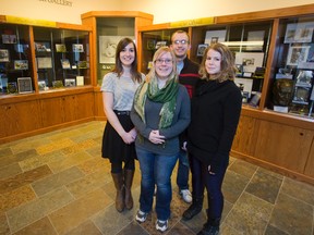 Masters of public history students Elizabeth Miron, left, Stacey Devlin, Joel Sherlock and Jessica Knapp show off a display featuring their research of heritage homes. Their work is on display in the archive wing of D.B. Weldon Library at Western University in London. (DEREK RUTTAN, The London Free Press)