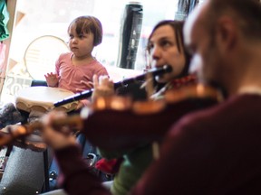 Three-year-old Ruby plays a drum alongside her mother Martha Cooper on Irish flute, and Paul Hawtin on fiddle, during an instrumental Irish Jam Session at the Ottawa Folklore Centre on Sunday March 16, 2014. 
Errol McGihon/Ottawa Sun/QMI Agency