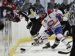 Kingston Voyageurs captain Michael Casale corrals the puck off the boards from Trenton Golden Hawks Jason Zaleski (21) and Zach de Concilys (53) during the second period of Game 3 of an OJHL North-East Conference semifinal playoff series at the Invista Centre on Sunday. Julia McKay/The Whig-Standard