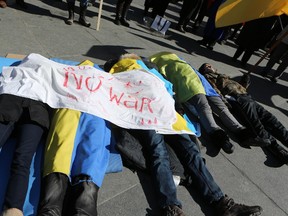 Hundreds of pro-Ukraine protesters, including several who played dead, took to Toronto's streets Sunday to demand that Russia withdraw from Crimea. (DAVE THOMAS, Toronto Sun)