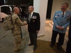 Maj.-Gen Dean Milner, final Afghanistan commander, left, shakes hands with Veterans Affairs Minister Julian Fantino as Cyprus mission veteran Lieut Ronald Griffis of Nova Scotia looks on in Cyprus on Saturday. (photo courtesy of Andrew Caballero-Reynolds)