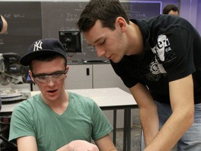 St. Christopher secondary students Steve Parr and Daniel Dennis work to build an egg launcher at last year's Impromptu Design Challenge held at Lambton College. The event, held as part of National Engineering Week, drew more than a dozen teams from schools across Sarnia-Lambton. (The Observer)