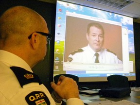 Ernst Kuglin The Intelligencer
Insp. Mike Reynolds, commander of the Quinte West OPP detachment watches a video presentation by Superintendent Rick Philbin on the controversial new billing method during a meeting of the local police services board (PSB) Monday. Quinte West may not get hits as hard as other municipalities, say city officials.