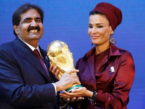 Qatar's Emir Sheikh Hamad bin Khalifa al Thani and his wife Sheikha Moza Bint Nasser al-Misnad hold a copy of the World Cup trophy he received from FIFA President Sepp Blatter (unseen) after the announcement that Qatar will be the host nation for the FIFA World Cup 2022, in Zurich in this December 2, 2010 file photo. (REUTERS)