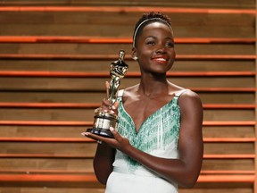 Actress Lupita Nyong'o poses with her best supporting actress award as she arrives at the 2014 Vanity Fair Oscars Party in West Hollywood, California March 3, 2014.  REUTERS/Danny Moloshok