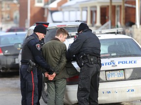 Kingston police arrest a man for a liquor offence on Aberdeen Street during St. Patrick's Day celebrations Monday.  
Elliot Ferguson The Whig-Standard