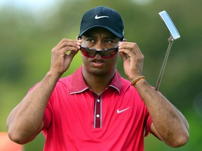 Tiger Woods puts on his sunglasses during the final round of the WGC - Cadillac Championship in Miami on Sunday, March 9, 2014. Woods is dealing with a bad back and is unsure of playing at the Masters next month. (Andrew Weber/USA TODAY Sports)