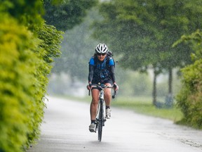 A cyclist braves the rain along the western Martin Goodman Trail lake shore bike trail in Toronto June 13, 2013. ERNEST DOROSZUK/Toronto Sun/QMI Agency