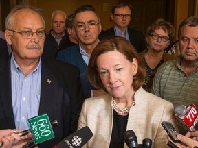 Flanked by supporters, including party president Jim McCormick (left), Premier Alison Redford speaks with media after an executive board meeting with the Progressive Conservative party of Alberta at the Clarion Hotel in Calgary, Alta., on Saturday March 15, 2014. 
Lyle Aspinall/Calgary Sun/QMI Agency