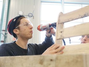 Gino Donato/The Sudbury Star
College Boreal Carpentry students Luc Pichette and Samuel Proulx work on a chair made out of a pallet. The Sudbury & District Homebuilders, as part of this year's Sudbury Home Show, are holding a Pallett Challenge in which participants build and showcase their creations at the show, which runs this weekend, March 21-23, at the Sudbury Community Arena. Participants include College Boreal Carpentry students, local media and business people.
