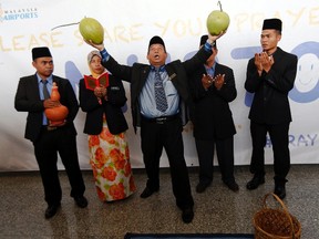 Ibrahim Mat Zin, centre, a local well-known "bomoh", or shaman, holds two coconuts as he performs a ritual to help find the missing Malaysia Airlines MH370 in a ceremony at Kuala Lumpur International Airport on March 12. 
Damir Sagolj/REUTERS